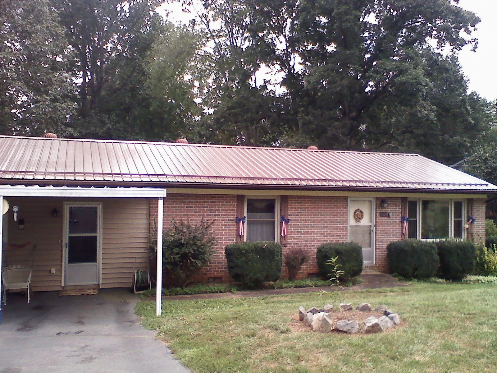 Bronze metal roof and carport on a brick ranch home — Roof Repair work by our crew in Fredonia